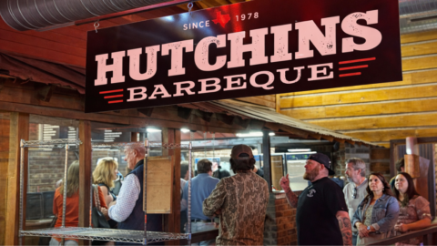 Hutchins BBQ sign hanging inside the dining area in McKinney, Texas